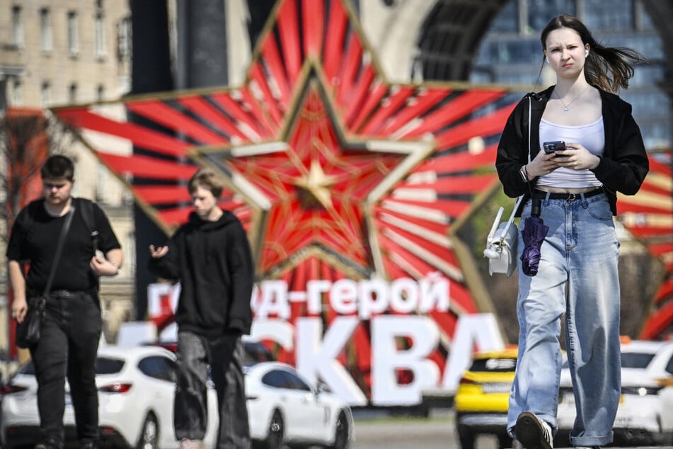 People walk past a decoration at Poklonnaya Hill in western Moscow on May 6, 2026, a few days ahead of the Victory Day military parade.