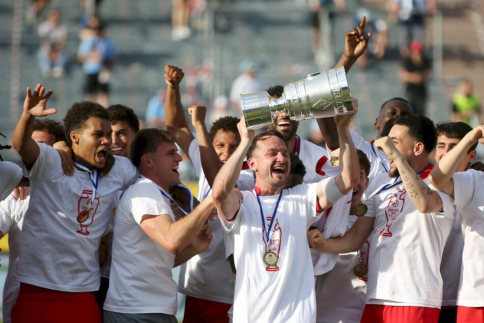 Würzburg-Kapitän Peter Kurzweg reckt in seiner Abschiedssaison die Pokaltrophäe in die Luft.