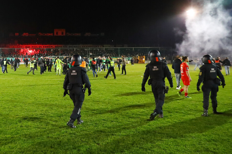 Nach dem Spiel wollten die Heimfans ihr Team auf dem Rasen feiern, sollen mit Böllern beschossen worden sein. Die Polizei musste eingreifen.