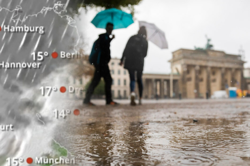 Passanten mit Regenschirmen gehen vor dem Brandenburger Tor.