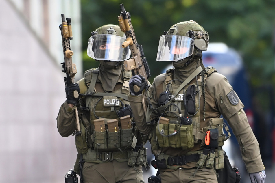 Schwer bewaffnete Polizisten bereiten sich auf den Einsatz in Köpenick vor.