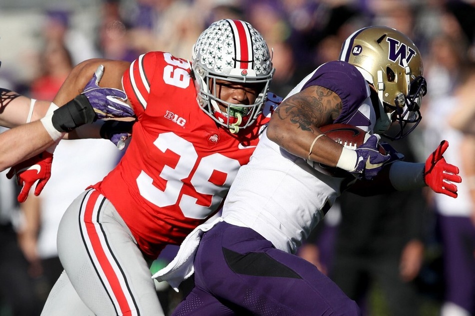 Malik Harrison of the Ohio State Buckeyes attempts to make a tackle during the first half in the Rose Bowl Game.