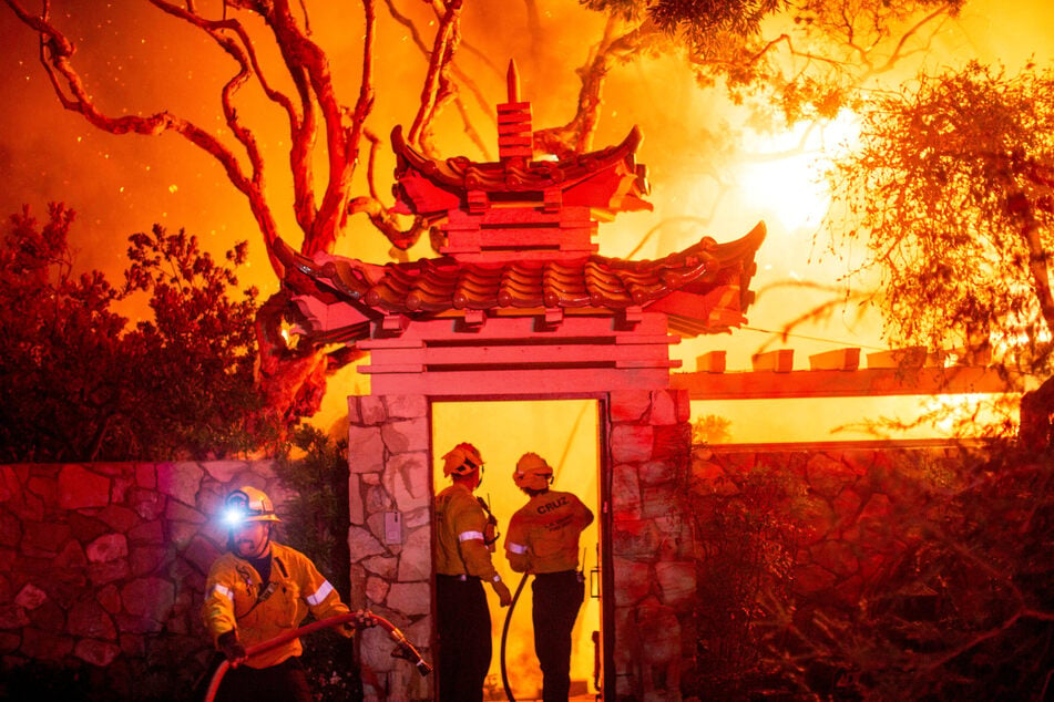 Firefighters battle the Palisades Fire as it burns during a windstorm on the west side of Los Angeles, California, on January 8, 2025.