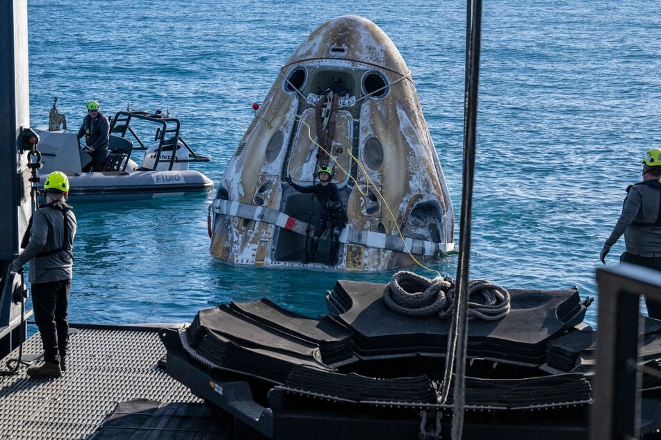 Support teams work around a SpaceX Dragon spacecraft shortly after it landed in the water off the coast of Tallahassee, Florida.