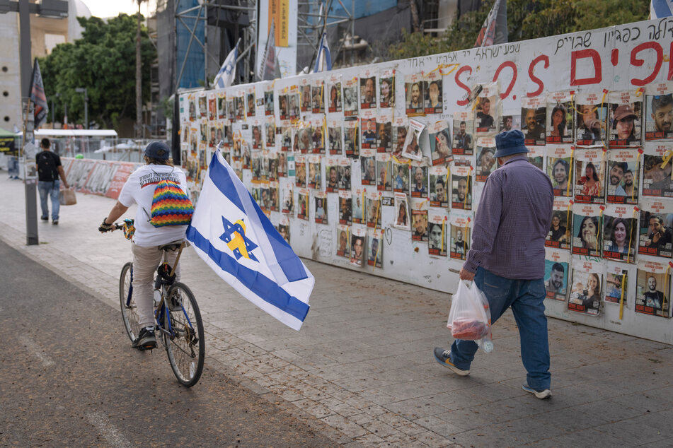 In Tel Aviv können Passanten Fotos der im Gazastreifen noch immer festgehaltenen Geiseln an einer Wand sehen.