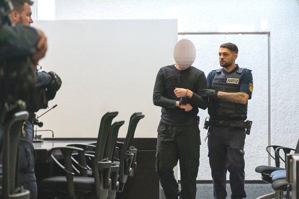 Ein Angeklagter wird in einen Saal im Landgericht Stuttgart geführt.