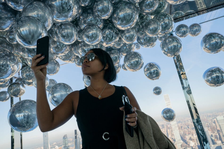 Eine Besucherin fotografiert einen Raum voller mit Helium gefüllter Ballons bei der Eröffnung der neuen Aussichtsplattform an Manhattans berühmter 42nd Street.