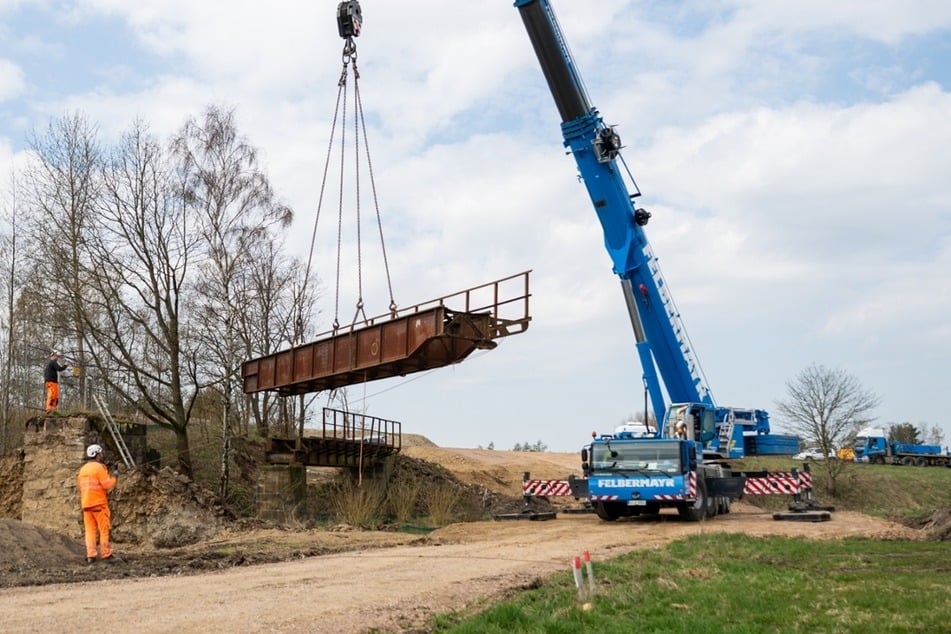 Ein Teil der alten Eisenbahnbrücke, die über den Holzbach führte, wurde am Donnerstag durch einen Kran ausgehoben.