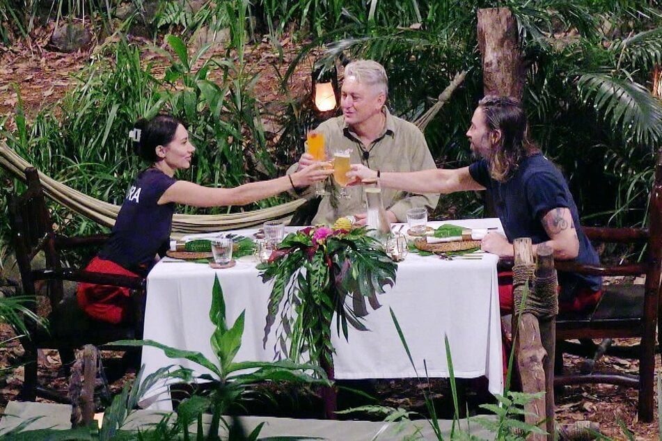 Beim letzten Abendmahl vor der Entscheidung stoßen die drei Finalisten nochmal feierlich miteinander an.