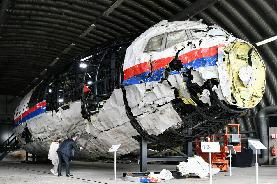 Investigators inspect Flight MH17, which was partially reconstructed from the wreckage.