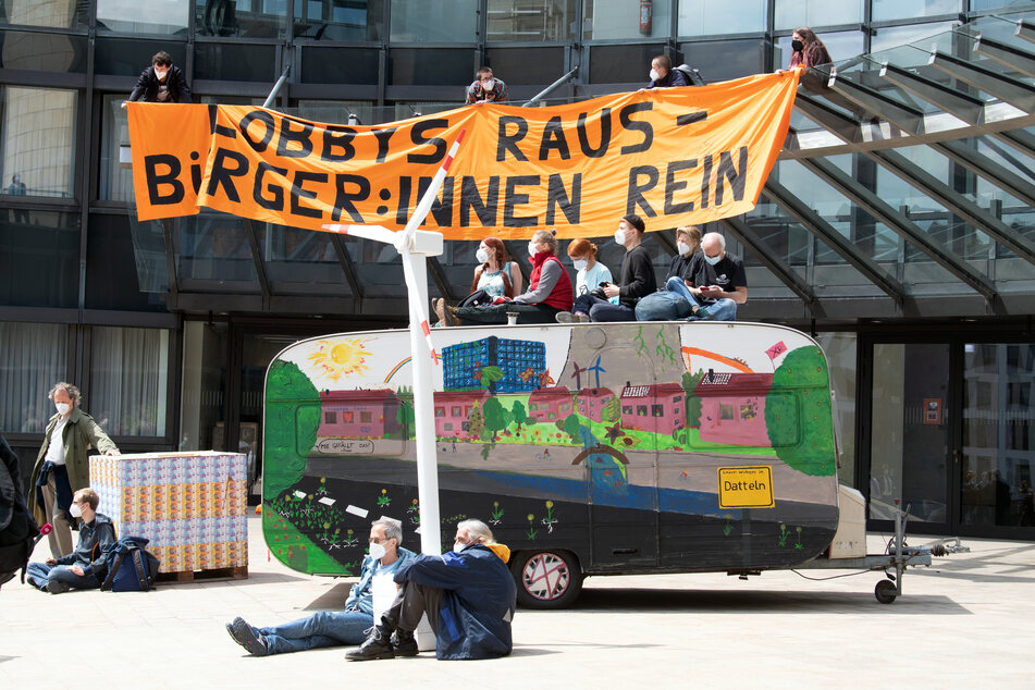 Einige Demonstranten kletterten auf das Vordach des Landtages und entrollten ein Transparent mit der Aufschrift "Lobbys raus - Bürger:innen rein".