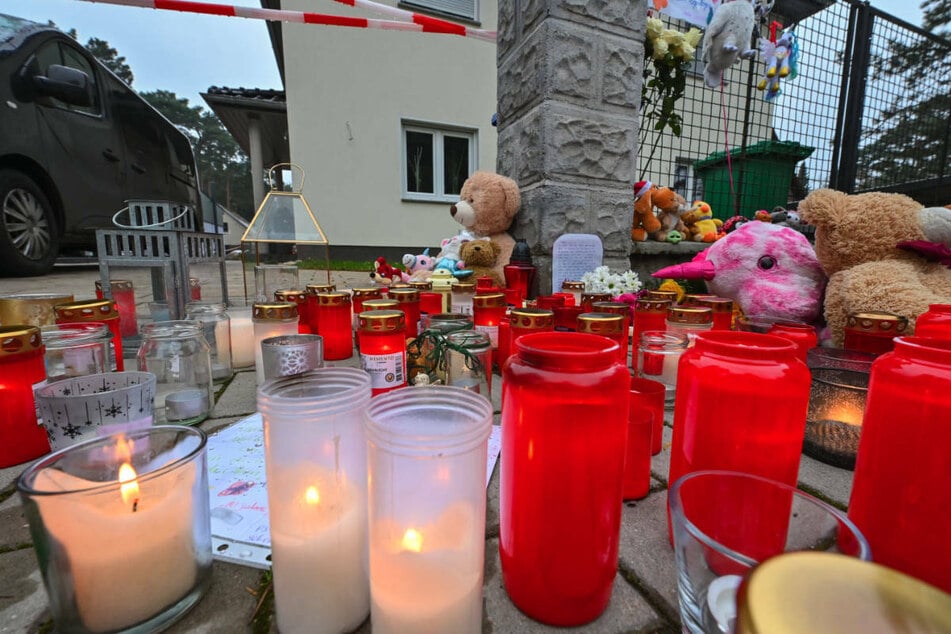 Vor dem Haus der Familie R. wurden im Gedenken an die Toten zahlreiche Kerzen gestellt und Stofftiere abgelegt.