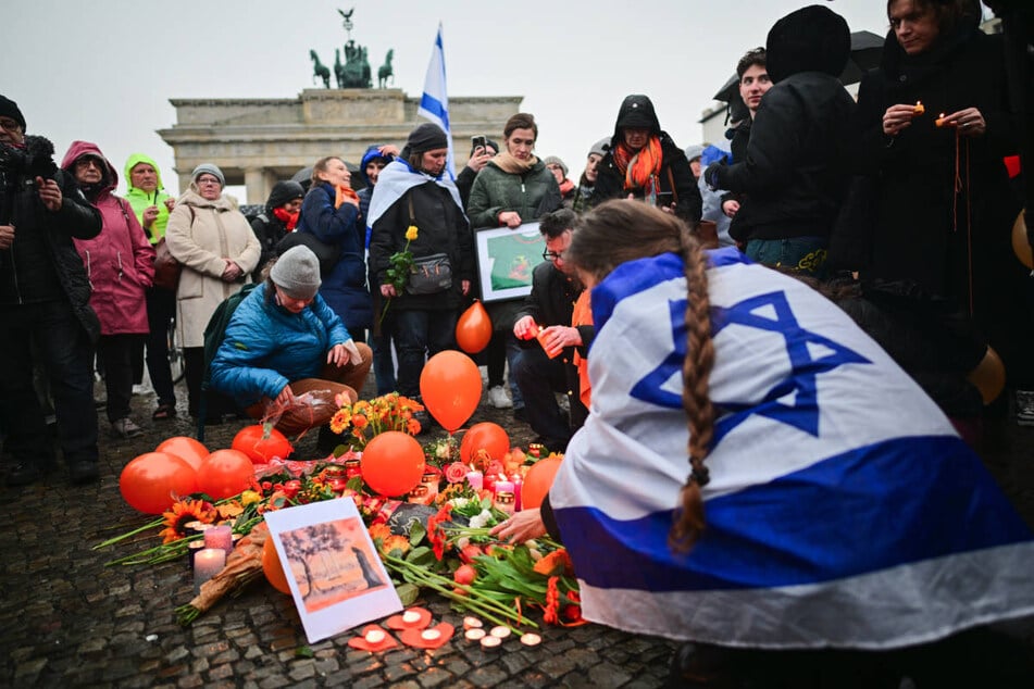 Vor dem Berliner Wahrzeichen sind als Zeichen der Anteilnahme Blumen abgelegt und Kerzen hingestellt worden.