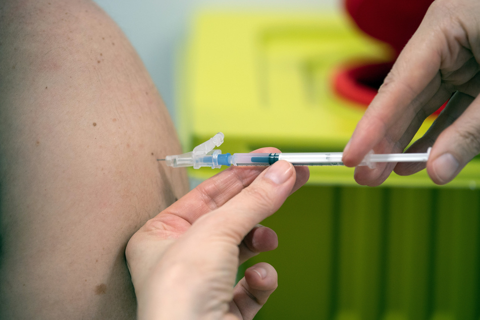 Eine Ärztin spritzt den Impfstoff von Moderna gegen Covid-19 in den Arm eines Mitarbeiters der Uniklinik Düsseldorf.