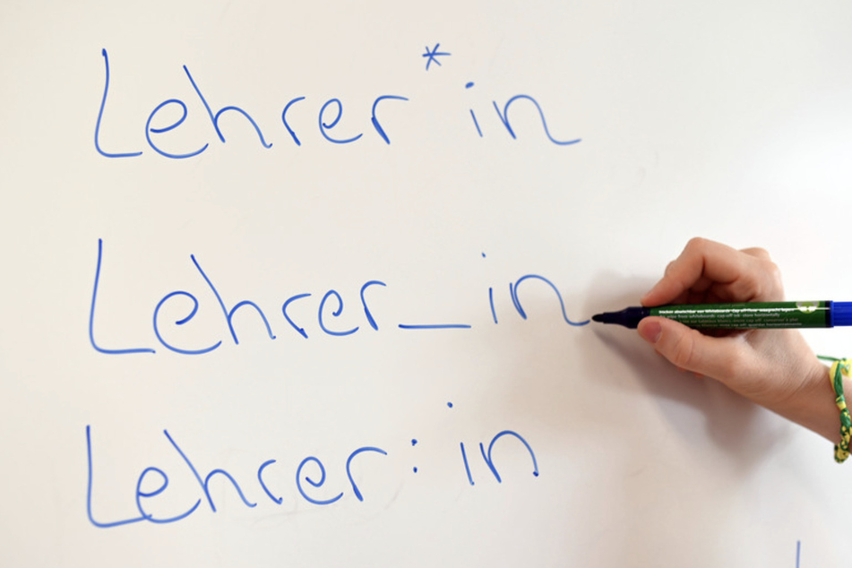An einem Whiteboard steht das Wort "Lehrer" in verschiedenen Gender-Schreibweisen.