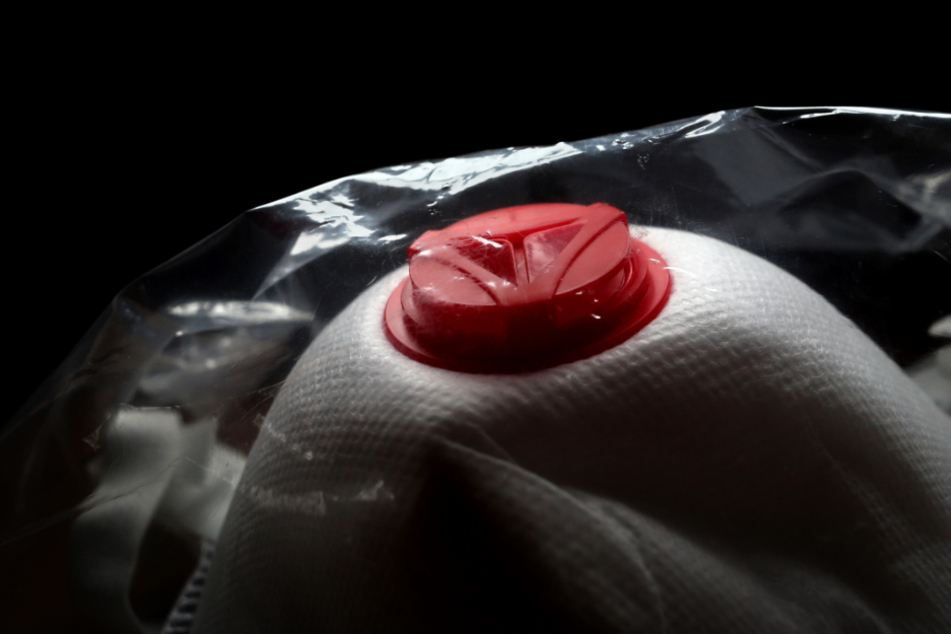 Eine FFP3 Atemschutzmaske liegt in Plastik verpackt auf einem Tisch.
