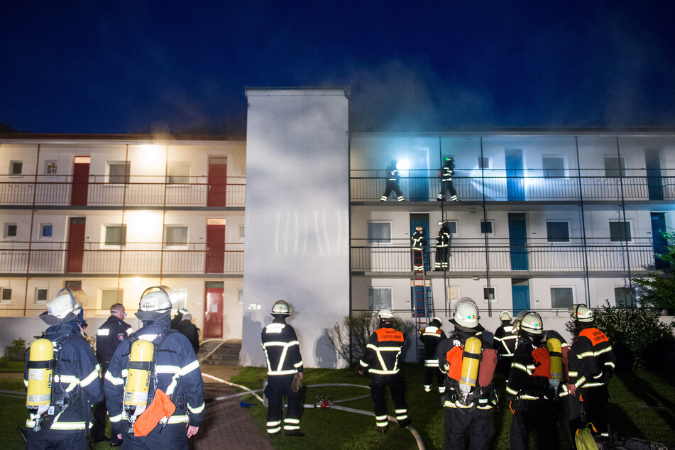 Feuerwehrleute sind bei einem Brand eines Mehrfamilienhauses im Einsatz. (Symbolbild)