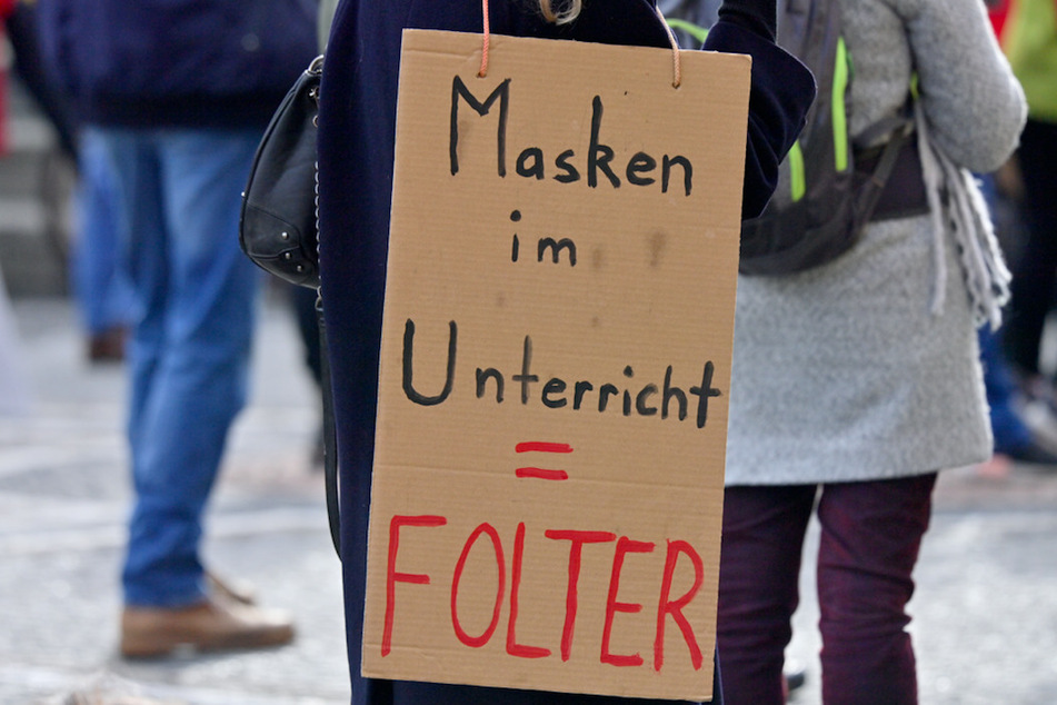 Mit Plakaten mit der Aufschrift "Masken im Unterricht - Folter" demonstrieren am Odeonsplatz mehrere hundert Menschen gegen das tragen von Mund-Nasen-Bedeckuungen in Schulen.