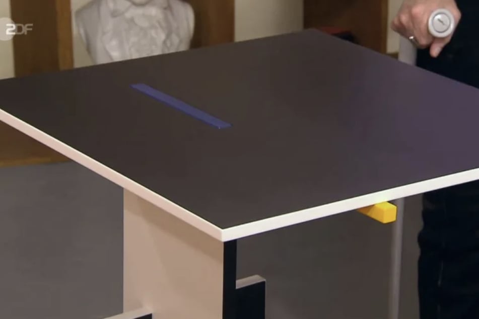 Bei dem Möbelstück handelt es sich um einen Designertisch vom niederländischen Designer Gerrit Rietveld.