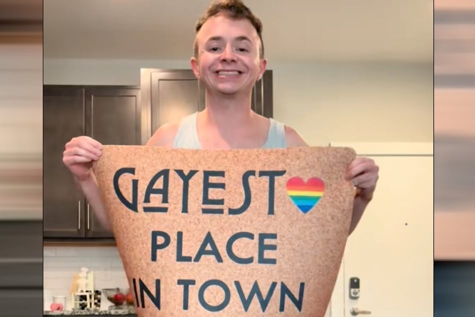Clay (29) kontert mit seiner eigenen "Gayest Place in Town"-Fußmatte.