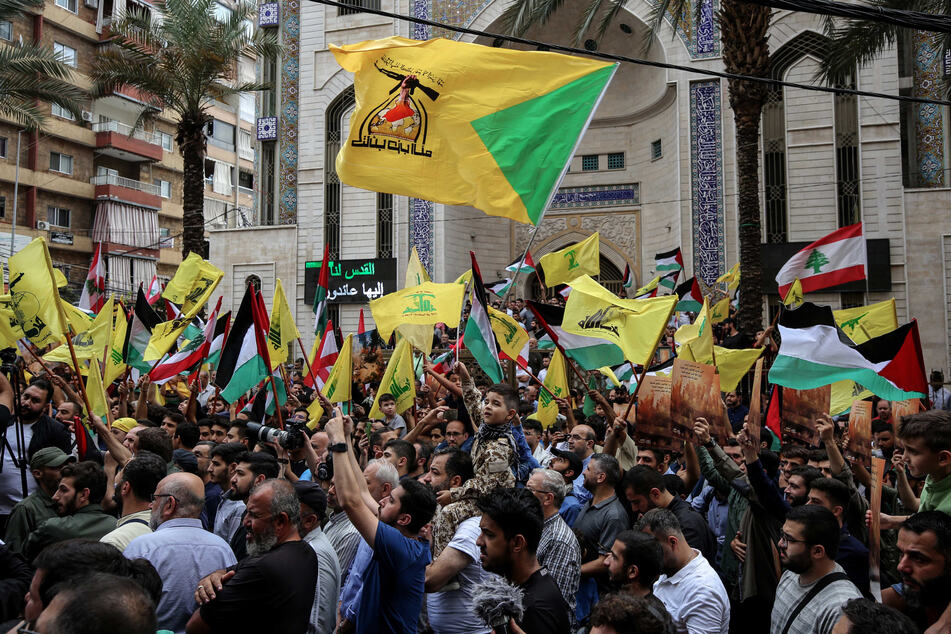 Beirut: Hisbollah-Anhänger schwenken bei einer Kundgebung ihre Fahnen. Die Schiitenorganisation Hisbollah hat nach dem Hamas-Angriff auf Israel ihre Solidarität mit der Hamas bekundet.