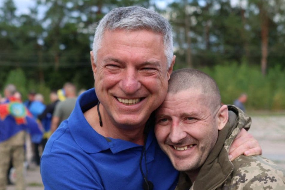 A staff member of the Coordination Headquarters for the Treatment of Prisoners (l.) embraces a Ukrainian prisoner of war following an exchange of prisoners on Sunday.