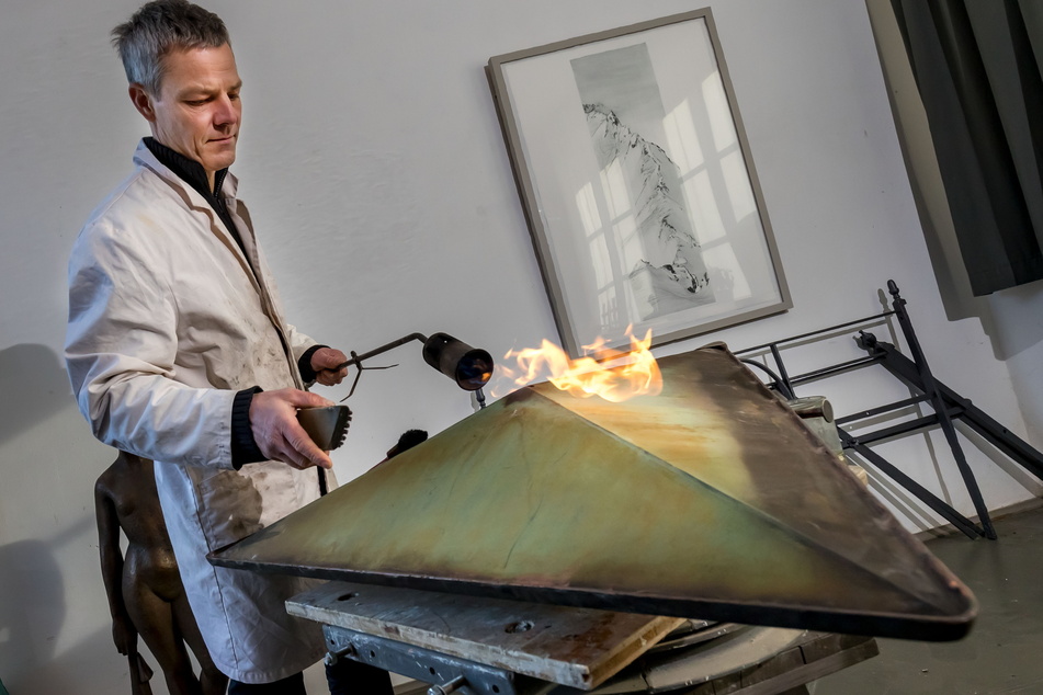 Mit einem Brenner und Chemikalien gleicht Erik Neukirchner (48) die reparierten Partien der Brunnenschale an die alte Patina an.