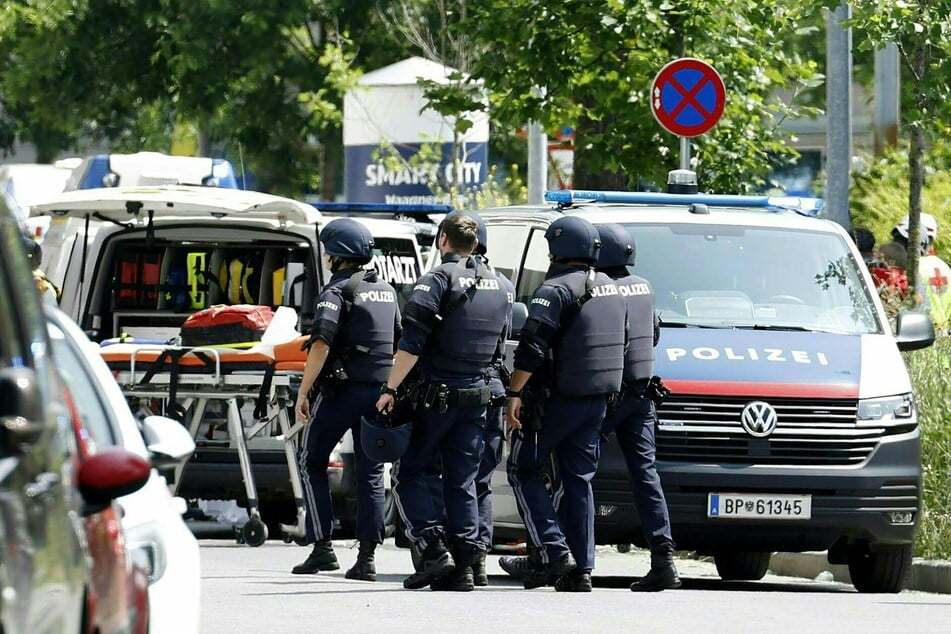 Einsatzkräfte der Polizei stehen in der Nähe des Tatorts an der Grazer Schule.