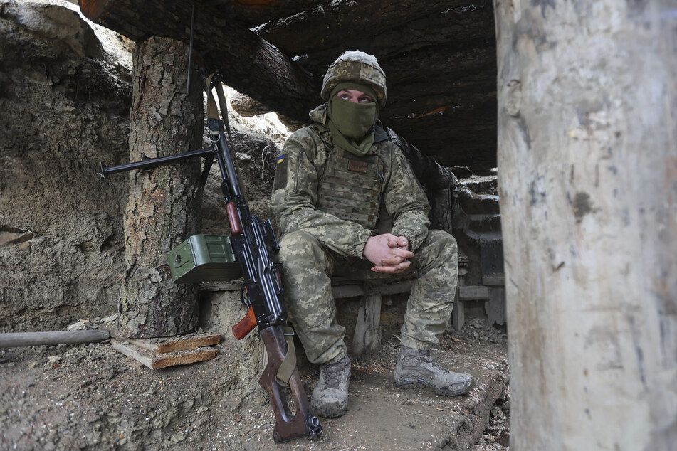 Ein ukrainischer Soldat sitzt in einem Graben an der Trennlinie zu prorussischen Rebellen. Der ukrainische Verteidigungsminister warnte, dass Russland schon bald in sein Land einmarschieren könnte.