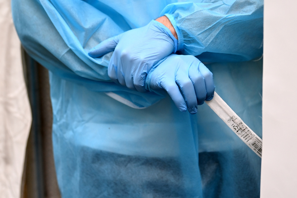 Medizinisches Fachpersonal wartet um einen Abstrich für einen Antigen-Schnelltests zu entnehmen. (Symbolbild)