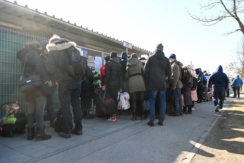 Geflüchtete warten vor einer Flüchtlingsunterkunft in München auf Einlass. Im Landkreis sind die Behörden mit der Anzahl der Menschen überfordert.