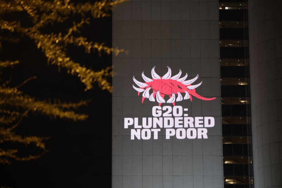 The Glasgow Actions Team project a message calling for debt justice onto the Sandton towers in Johannesburg, South Africa, on November 19, 2025, ahead of the G20 leaders’ summit.