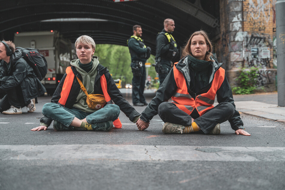 Klimaaktivisten kleben auf einer Straße in Berlin.