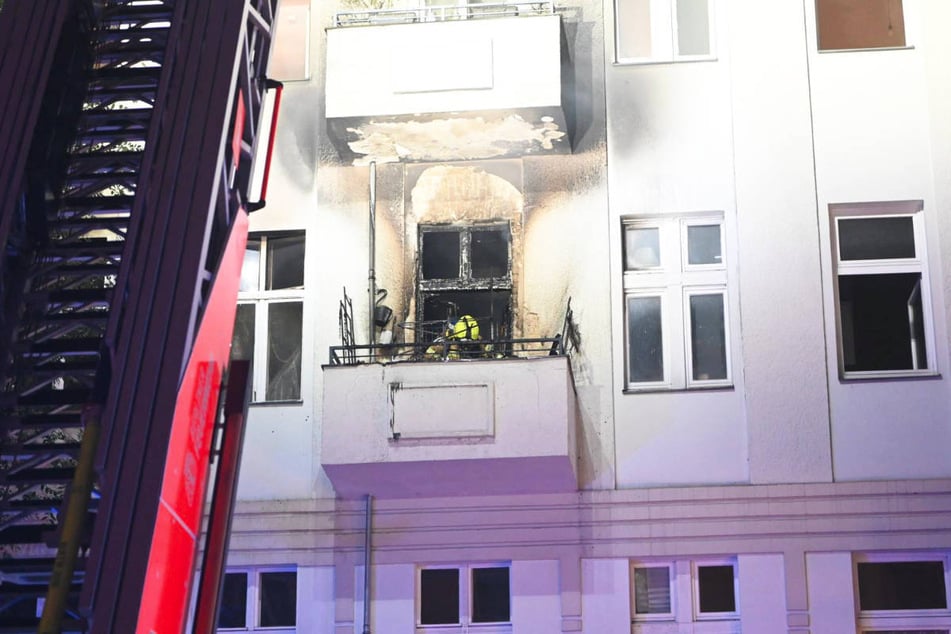 Ein Feuerwehrmann untersucht den Balkon der Brandwohnung.