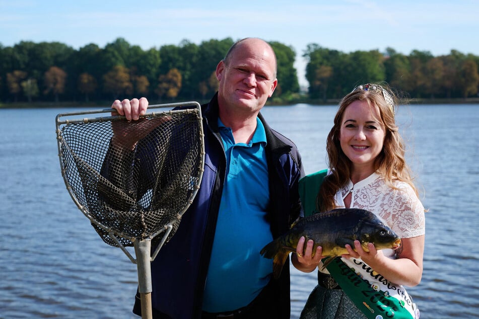 Henry Lindner von der Teichwirtschaft Moritzburg, und die Moritzburger Fischkönigin Janine Rossol mit einem Karpfen am Schlossteich.