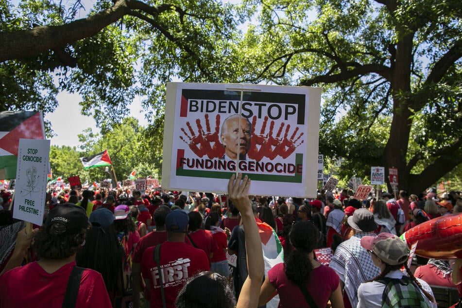 A demonstrator holds a sign reading "Biden Stop Funding Genocide" during a protest against US support for Israel in Washington DC.