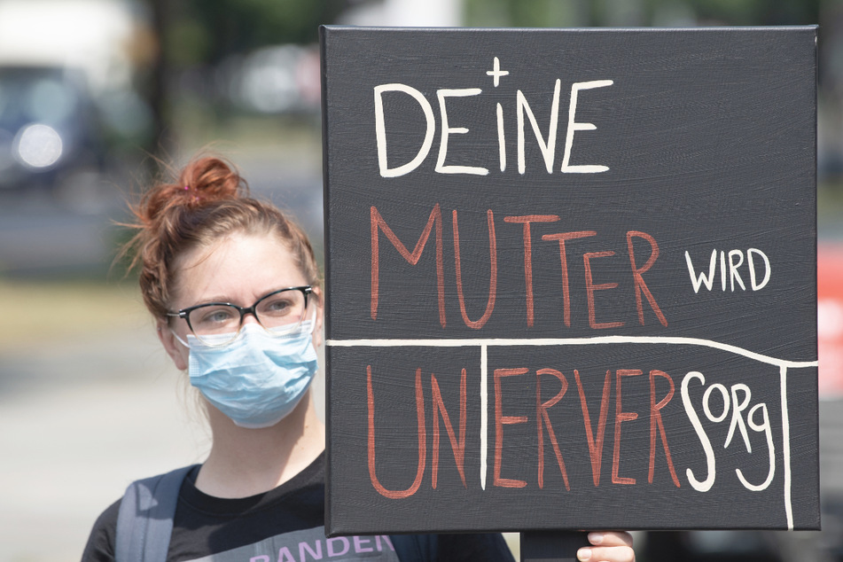 Eine Teilnehmerin einer Kundgebung der Dienstleistungsgewerkschaft Verdi hält in Dresden ein Plakat mit der Aufschrift "Deine Mutter wird unterversorgt" in der Hand. In ganz Deutschland finden am Mittwoch Protestaktionen statt.