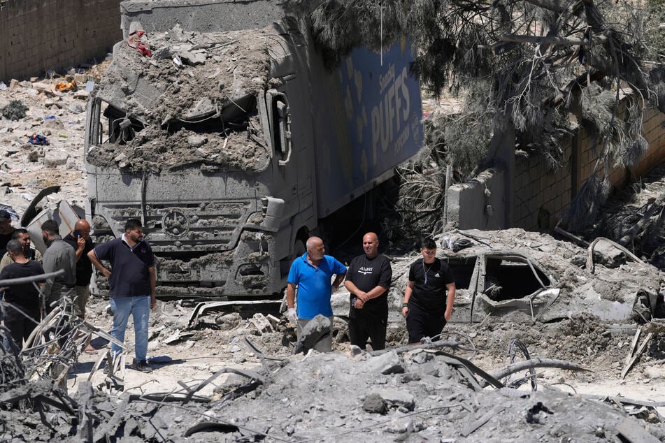 So sehen Israels Verstöße aus: Menschen versammeln sich an der Stelle eines zerstörten Gebäudes, das bei einem israelischen Luftangriff im Dorf Qannarit im Südlibanon getroffen wurde.