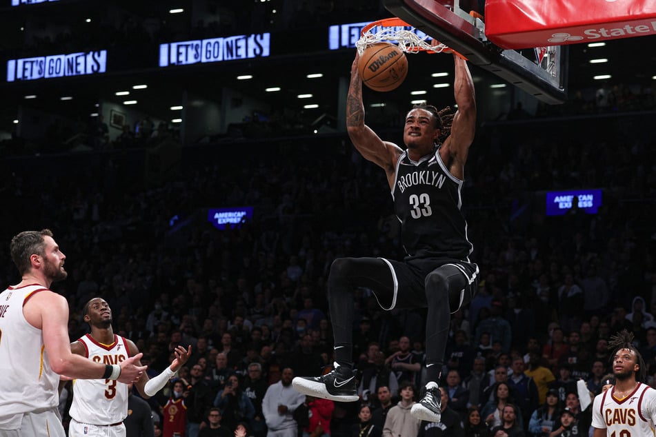 The Nets' Nic Claxton duking the ball against the Cavs.
