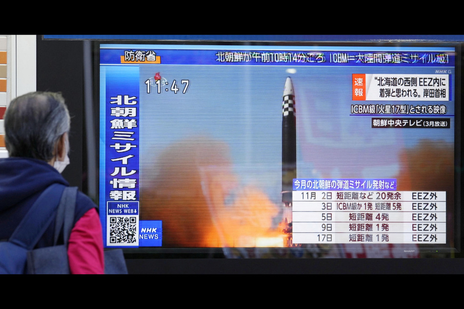 A passerby in Tokyo, Japan, looks at a television screen showing a news report about North Korea firing a ballistic missile.