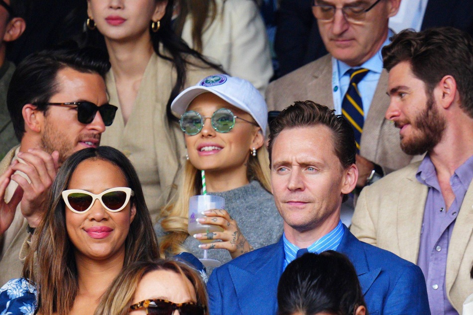 Ariana Grande (c.) attends the Wimbledon match and sits between actors Andrew Garfield (r.) and Jonathan Bailey (l.) - but her husband, Dalton Gomez, was no where in sight.