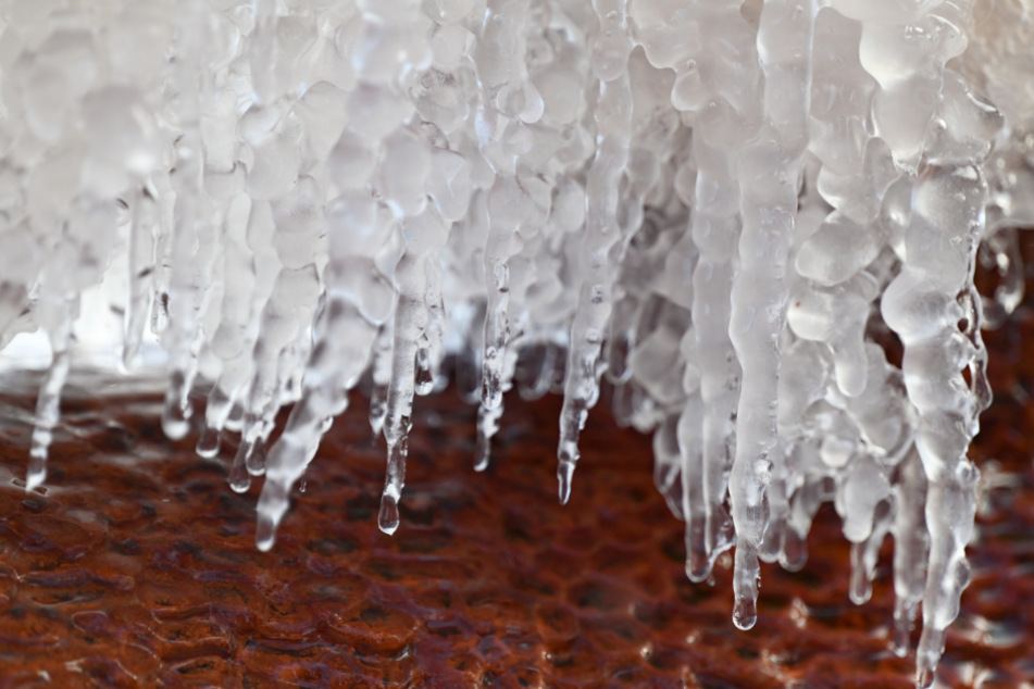 Eiszapfen am Rande des Römerbrunnens im hessischen Bad Vilbel.