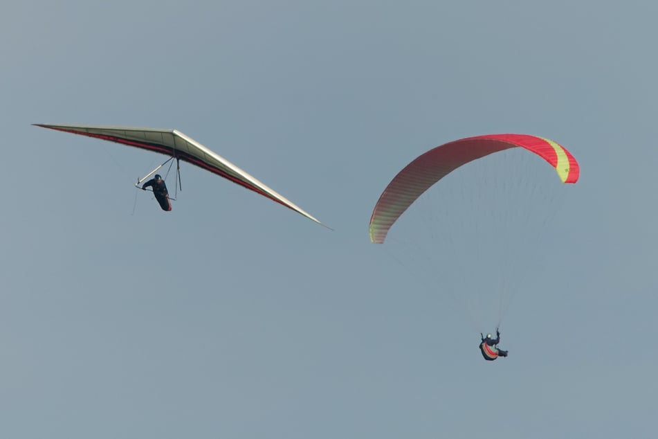 Mit einem Drachenflieger (l.) und einem Gleitschirm sind zwei Urlauber aus Deutschland in Österreich verunglückt. (Symbolbild)