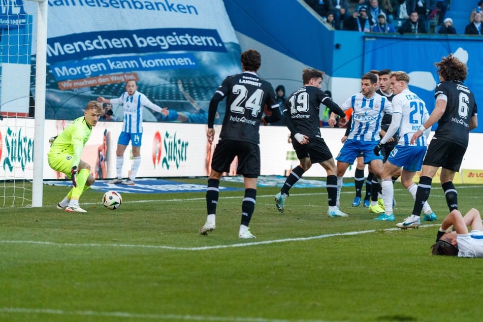 Während Hansa-Torjäger Sigurd Haugen (rechts am Bildrand) am Boden liegt, spielen seine Teamkollegen weiter und treffen!