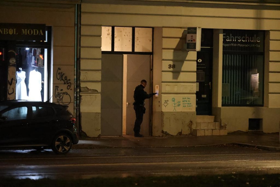 Ein Polizeibeamter vor der Haustür einer der drei Tatverdächtigen in Leipzig-Ost.