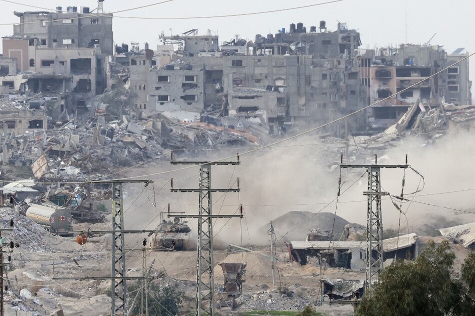 An Israeli military tank drives through destroyed Gaza near the Israeli border, on December 24, 2023.