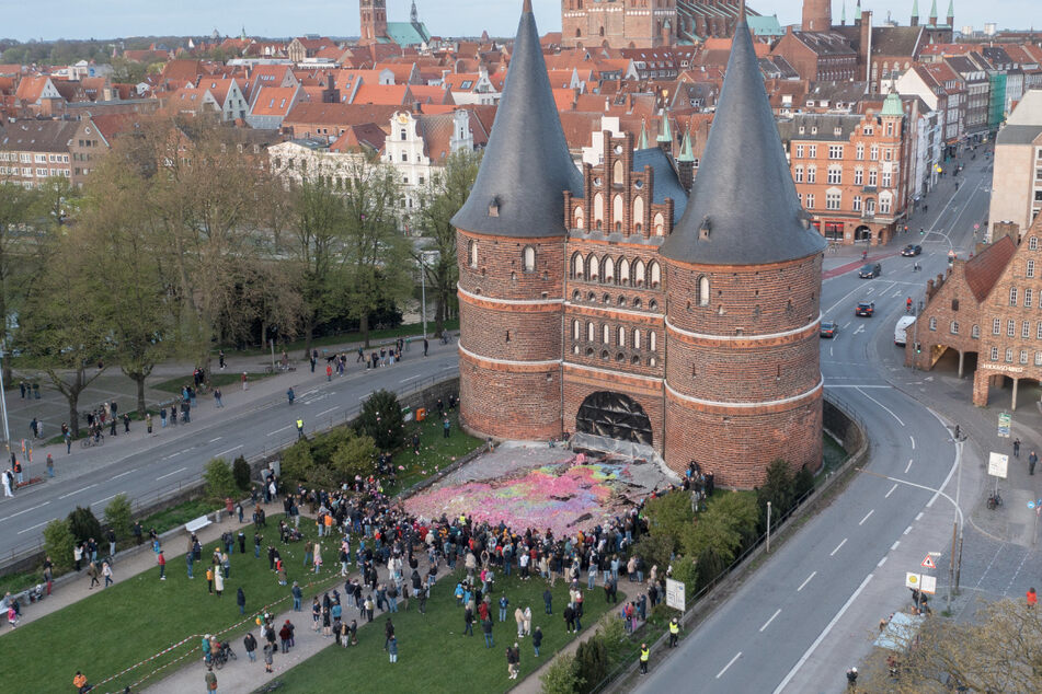Bei der Kunstaktion breitete sich der Schaum vor dem Lübecker Holstentor aus.