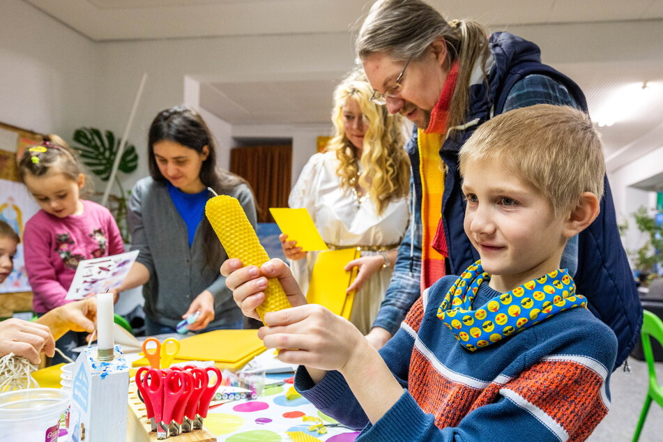 Priscian (8) zeigt stolz seine selbst gemachte Bienenwachskerze.