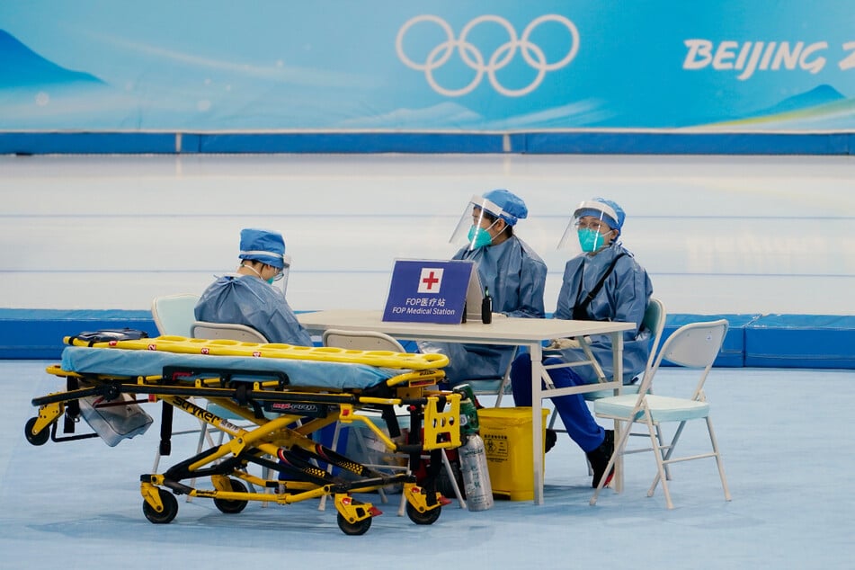 Corona-Vorbereitungen in der Nationalen Eisschnelllaufhalle "The Ice Ribbon" in Peking: Mitglieder eines medizinischen Teams verfolgen die Trainingsläufe.