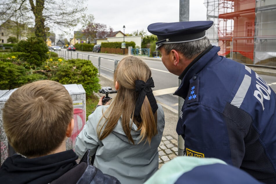 Polizeihauptmeister Mario Meyer (56) erklärt den Kindern das Lasermessgerät.